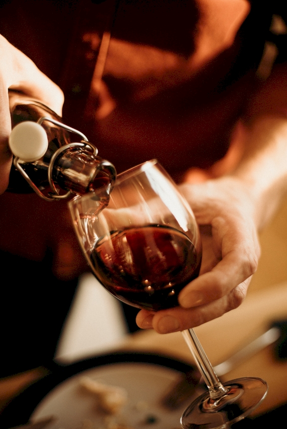 Sommelier pours red wine into wine glass